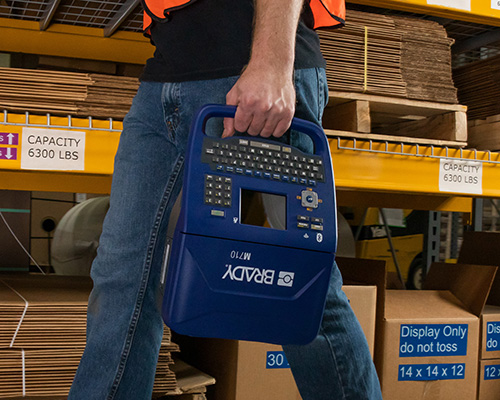 The M710 label printer is carried through a manufacturing facility.