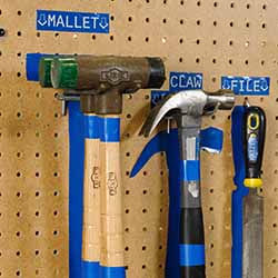 Tools organized on a pegboard with identifying shapes and labels.
