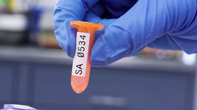 A lab technician holding a test tube with a Brady chemical resistant, low temperature label.