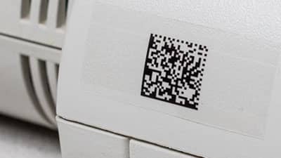 A Brady multipurpose clear polyester label applied to a piece of office equipment.