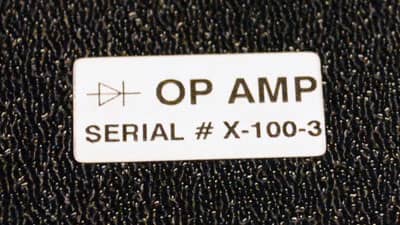 A Brady multipurpose label with aggressive adhesive applied securely to a textured surface.