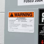 A Brady arc flash warning label applied to an electrical panel