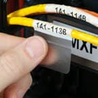 A technician applying a Brady self-laminating label to data cable to identify its purpose.