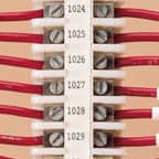 A number of Brady terminal block labels applied to a terminal block to identify each numbered terminal.