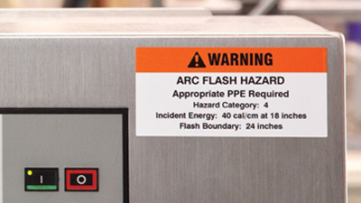 An arc flash hazard warning label on a piece of manufacturing equipment.