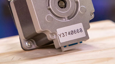 A small machine piece with a polyester label.