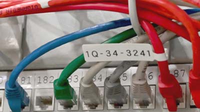 A Brady P-Flag type label made of matte polypropylene applied to Cat-5e ethernet cable.