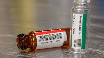 Two vials with a red and green coloured polyester labels.