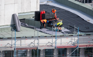 worker on the roof of a building under construction